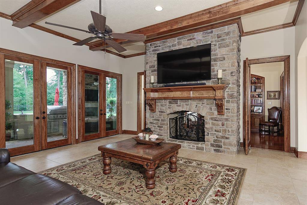 Family room highlights include wood ceiling beams, stone fireplace, tv mounting and wood mantle.