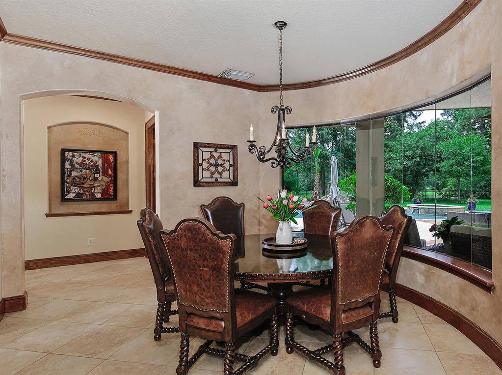 Sunny breakfast room with large windows overlooks the backyard and golf course