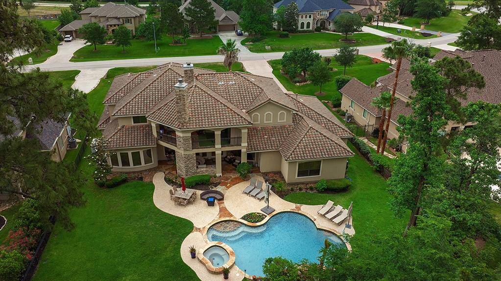 Backyard oasis features a stunning pool with a rock waterfall and spa, surrounded by lush greenery and mature trees. There are comfortable lounge areas are perfect for enjoying the golf course views, relaxation and recreation.