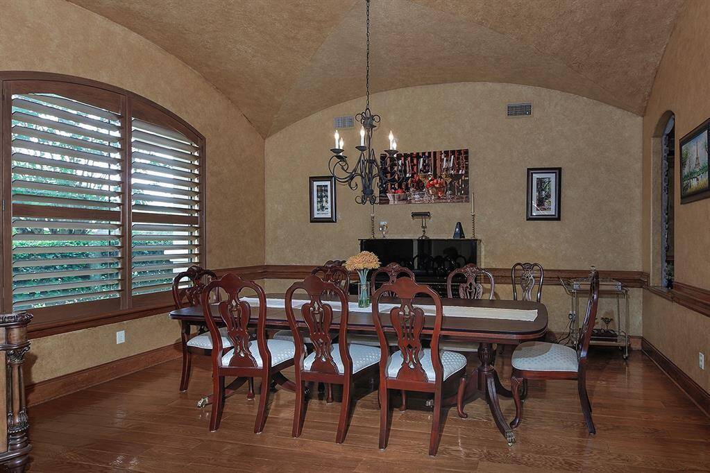 Sizeable dining room with a vaulted ceiling, wood trim and warm, earthy tones creating an ideal space to gather and entertain.