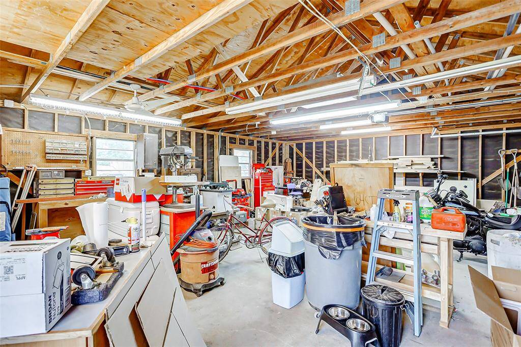 This spacious garage features a high ceiling, ample lighting, & abundant storage space.
