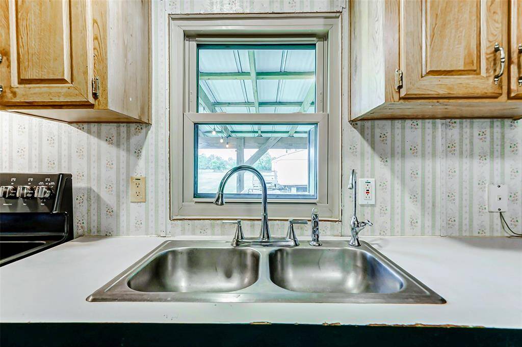 Double sink & stainless steel faucet complete with a kitchen window.