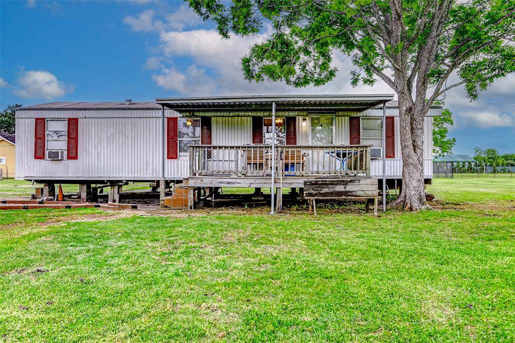 Second single family home with covered front porch, set on a spacious grassy lot.