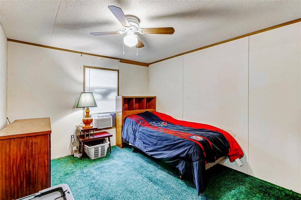 Secondary bedroom with ceiling fan, a/c unit & lush carpet.