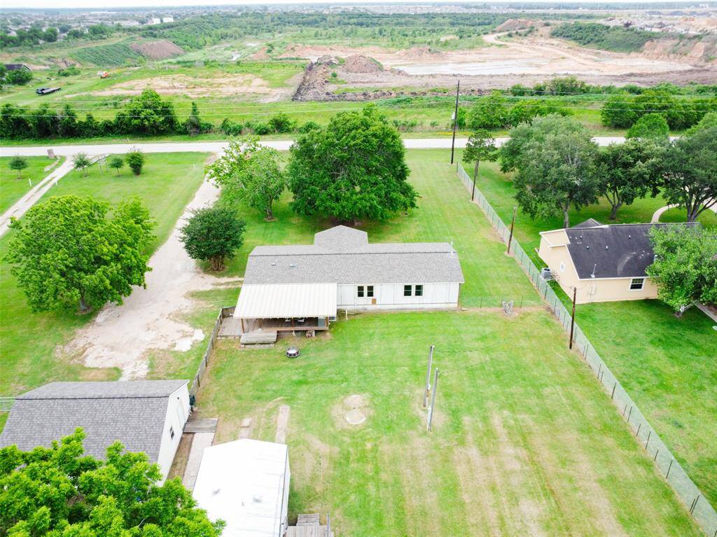 Large fenced backyard, covered patio, and spacious lawn.