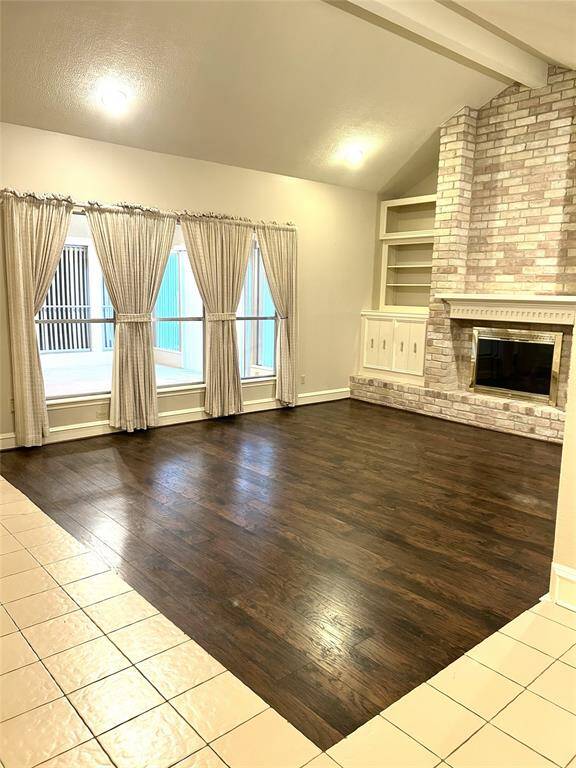 LIVING SPACE.. W/WOOD TYPE FLOORS.. FIREPLACE WALL W/BUILT-INS ON BOTH SIDES.. VIEW THRU WINDOWS OF SUN/GAME ROOM