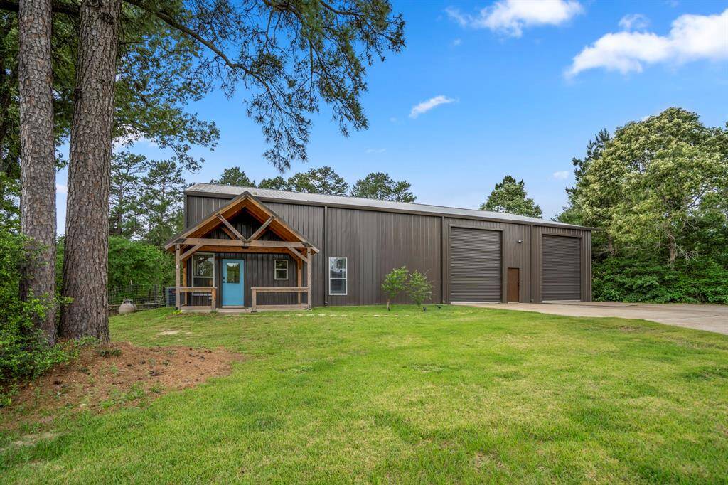 You will fall in love with country living in Navasota! This charming Barndominium features a wooden porch, set amid lush greenery and mature trees, offering a serene and private setting.