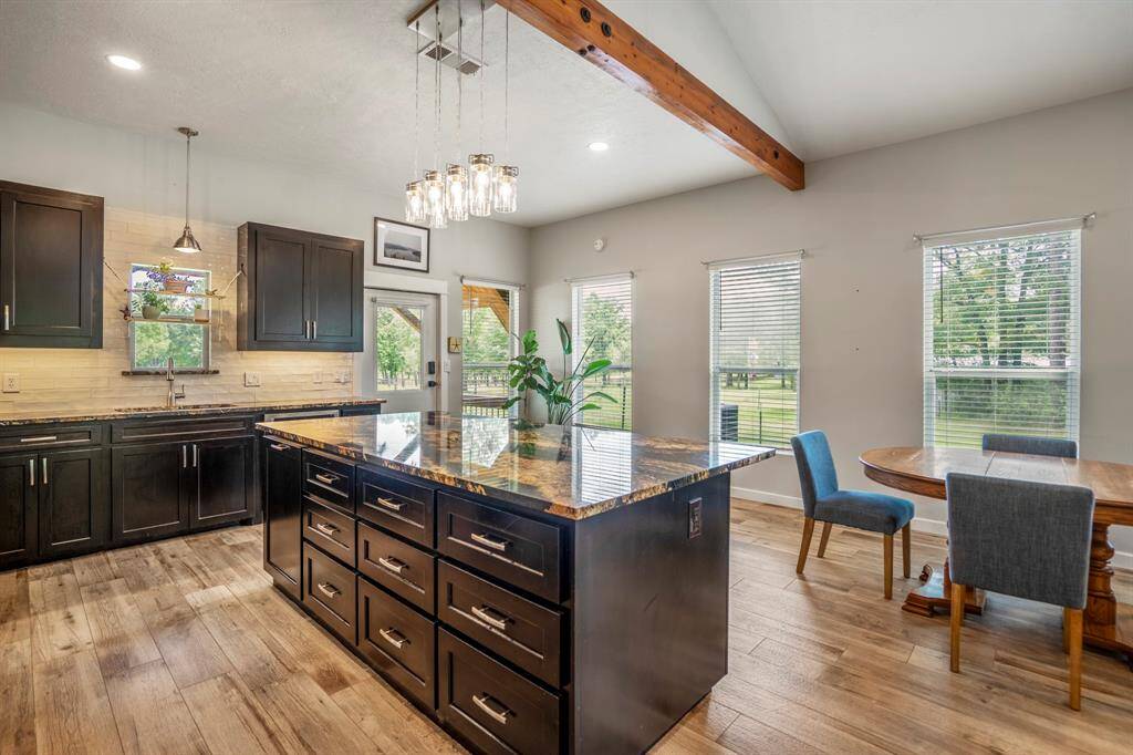 Notice all the natural light flooding through multiple windows, highlighting the open layout and warm tile flooring.