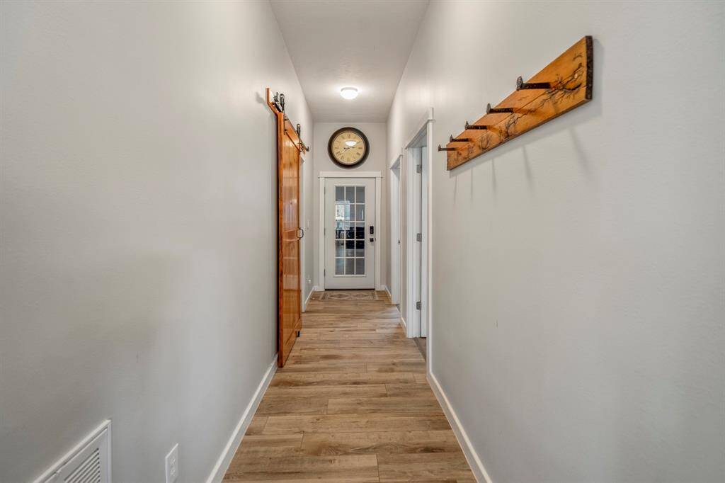 The hallway leads to the laundry room and secondary bedroom.  The shop/garage area is beyond the door.