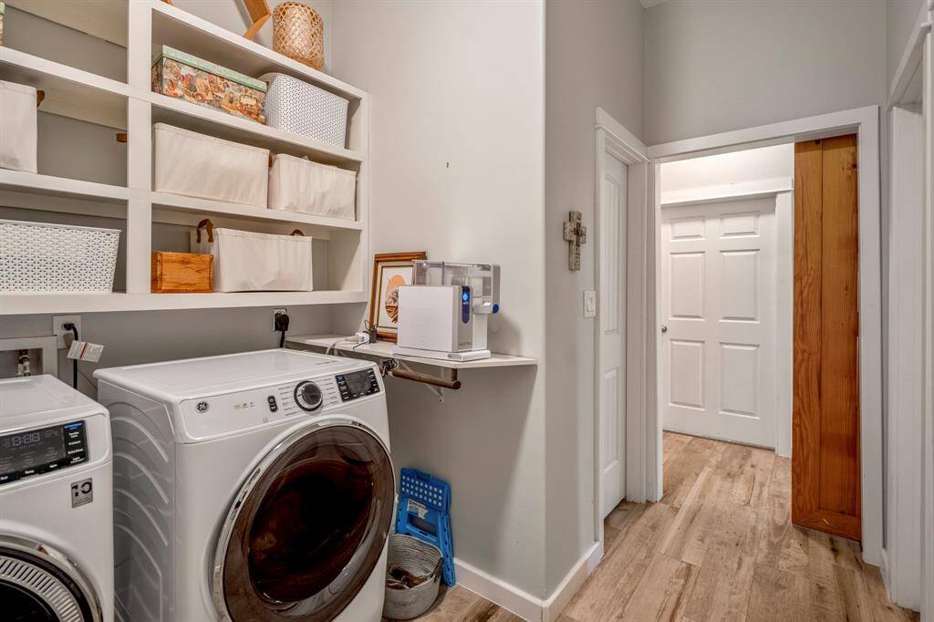 The laundry room features ample built-in shelving for storage and has an additional storage closet and a barn door.