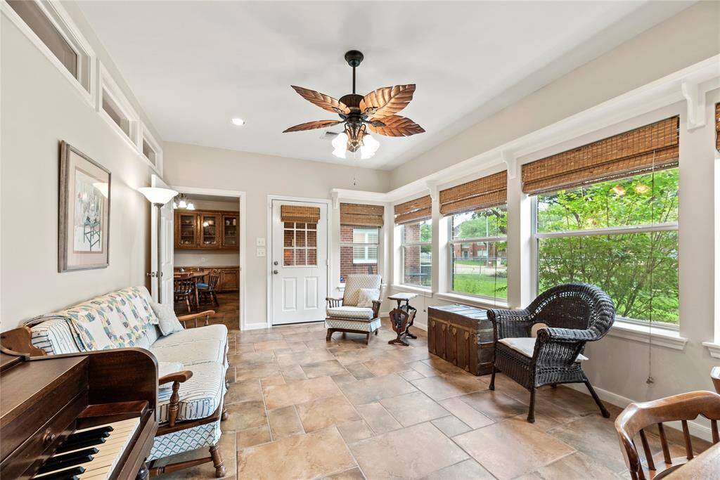 The sunroom is bathed in natural light, thanks to an abundance of windows, while the easy-care tile flooring adds both beauty and practicality to this serene space.
