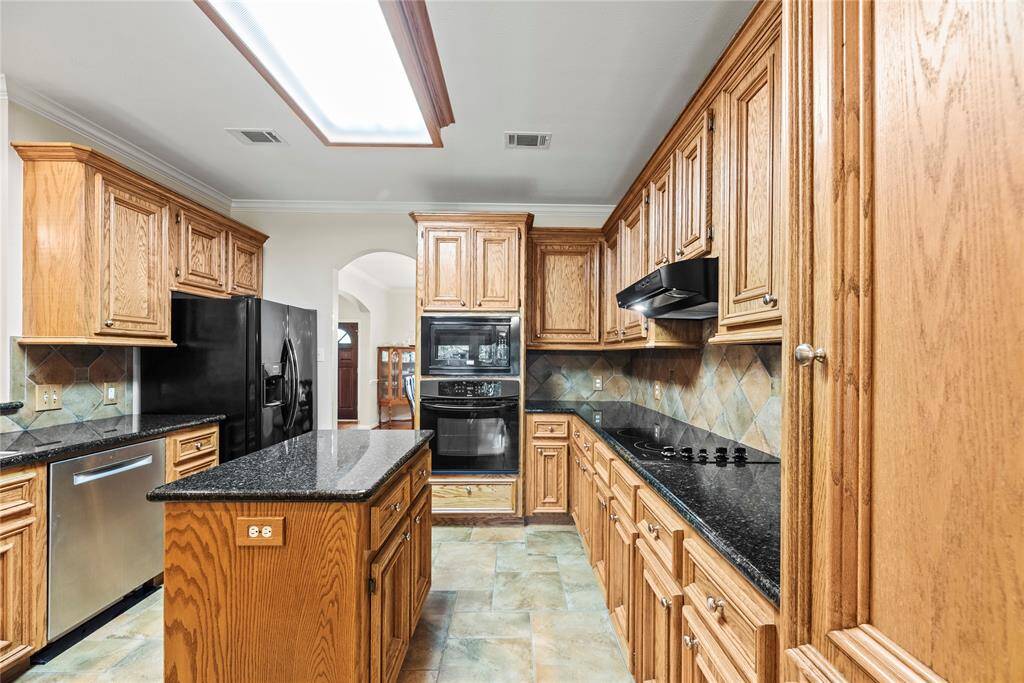 Your chef-inspired kitchen is ready to impress! This beautifully designed space boasts gleaming granite countertops, a coordinating stone backsplash, and sleek appliances. The rich cabinetry, enhanced with updated hardware, is perfectly complemented by tons of lighting, creating a bright and inviting ambiance. At the heart of it all, a sprawling center island, seating serves as a versatile centerpiece, providing additional workspace and storage.