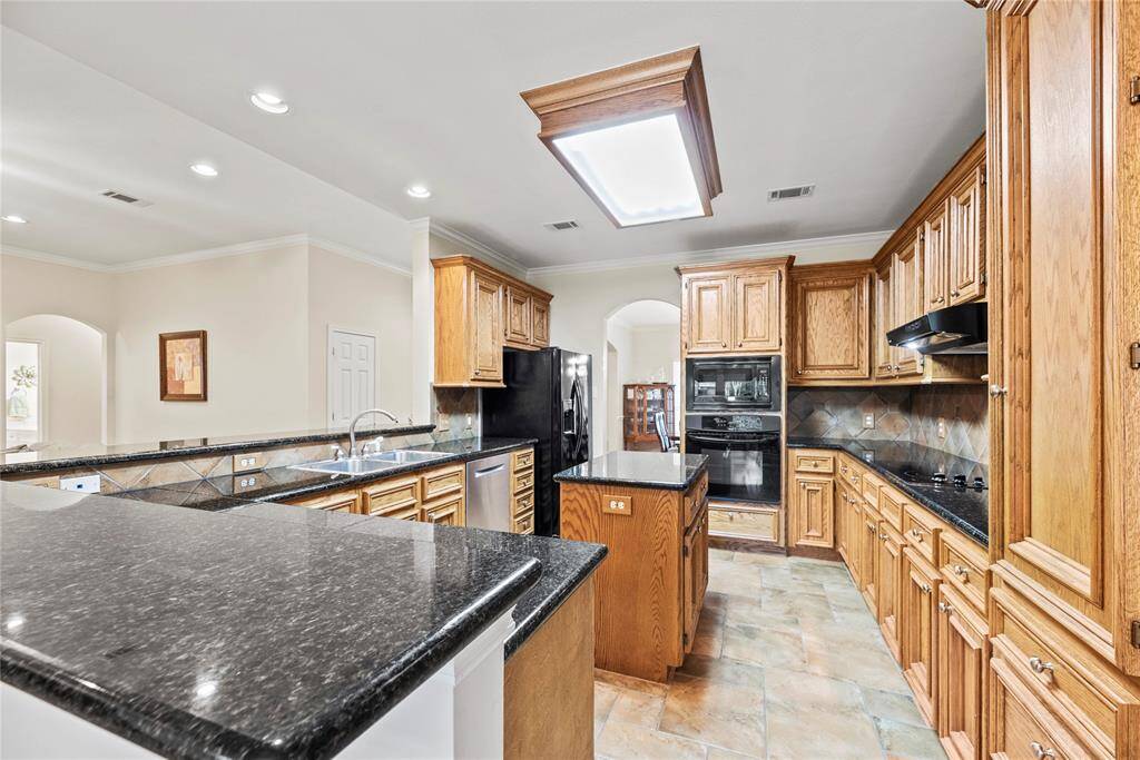 Granite countertops paired with a coordinating stone backsplash not only provide a durable and elegant surface for food preparation but also add a touch of luxury and sophistication to the kitchen.