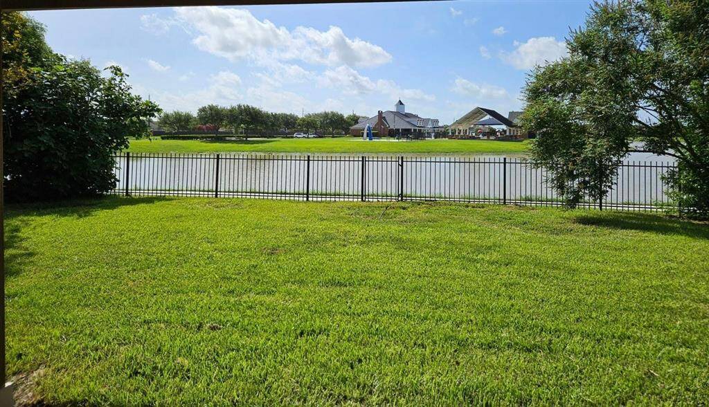 An expansive, lush lawn stretches toward the peaceful lakefront, creating a tranquil outdoor escape with no rear neighbors—perfect for relaxing evenings or open-air gatherings.