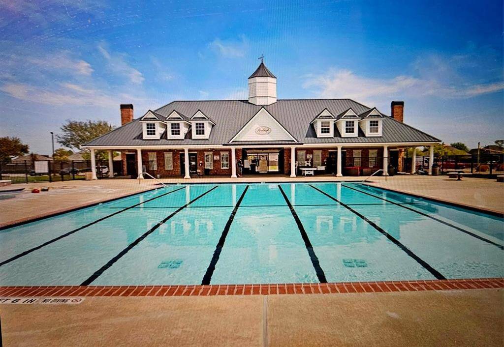 A sparkling community pool sits beside the clubhouse, surrounded by lounge areas—ideal for sunny days and social afternoons.