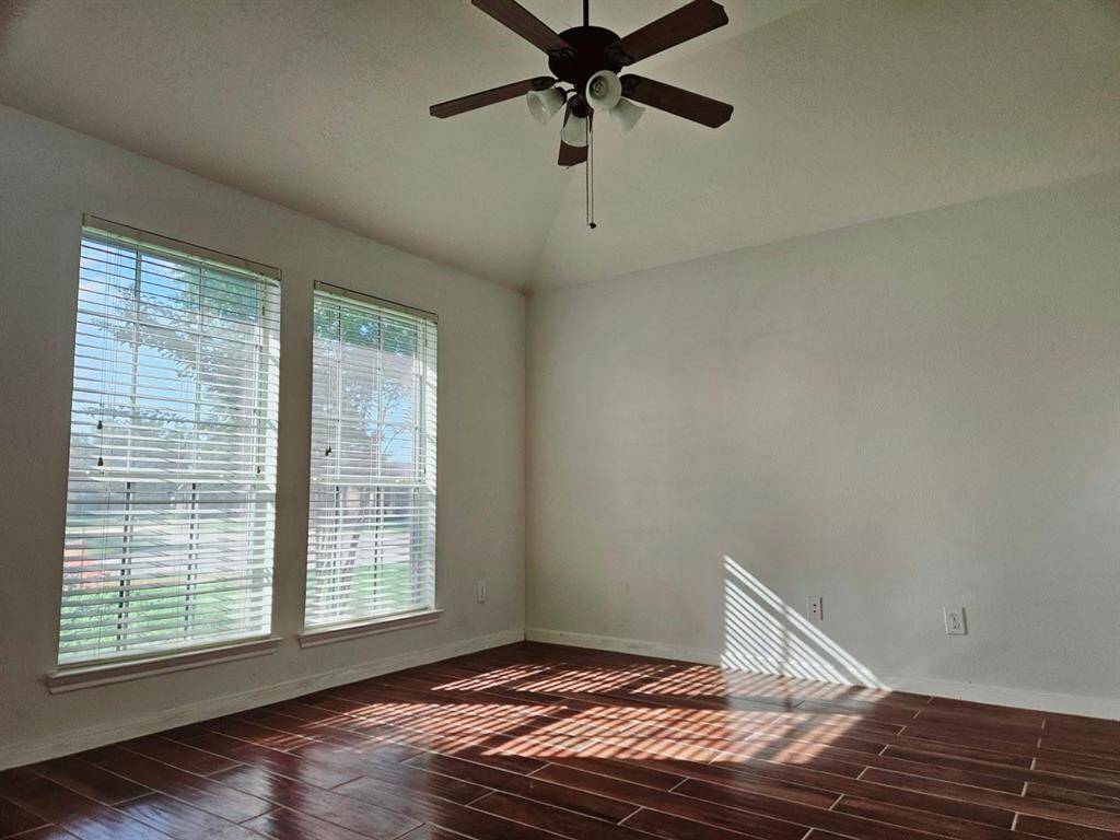 This dedicated workspace is both elegant and efficient, with tall ceilings, generous windows, and a ceiling fan that keeps the room bright and breezy for focused productivity.