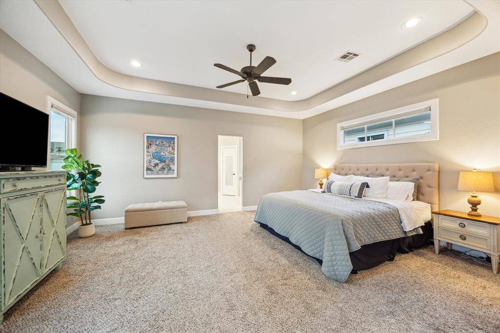 The primary suite offers enough space for a sitting area. The opening leads to the ensuite bath.