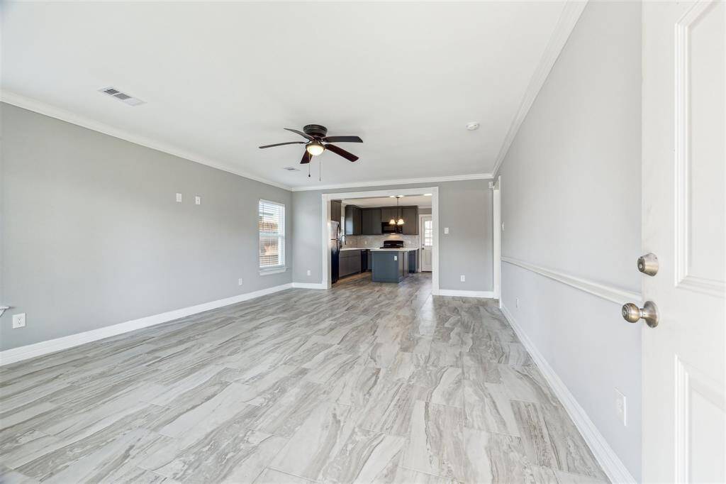 Open concept Living / Dining / Kitchen with ceramic tile and crown molding.