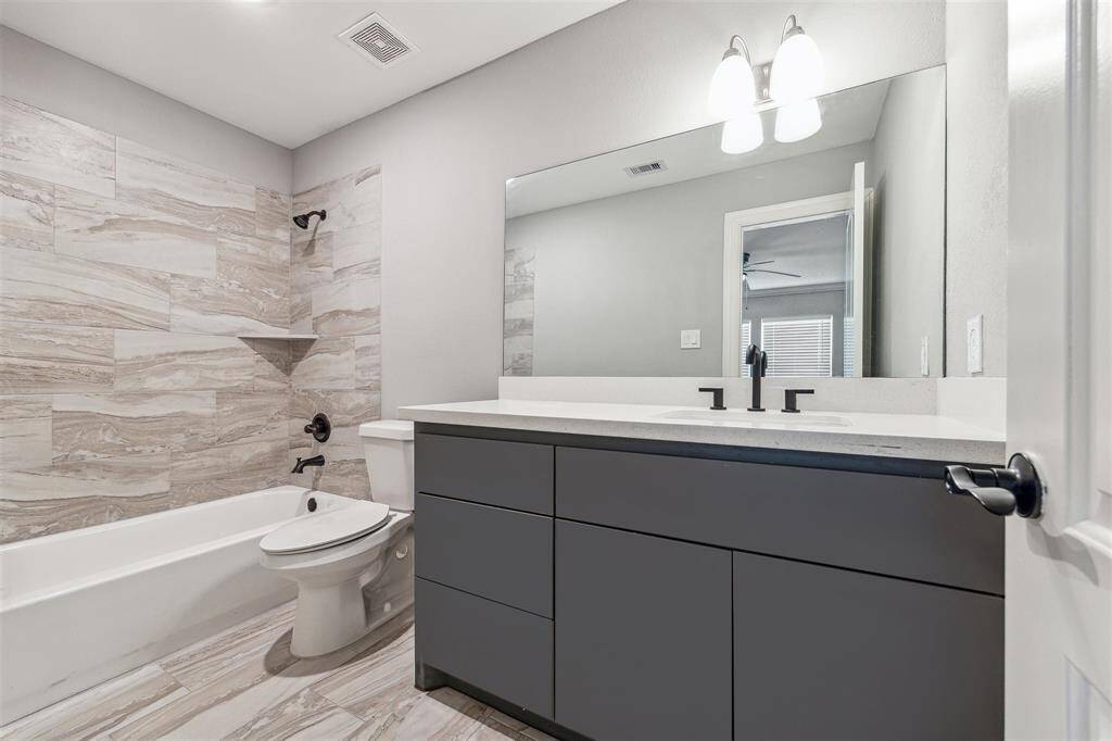Primary bathroom with oversized sink vanity and a tub/shower combo.