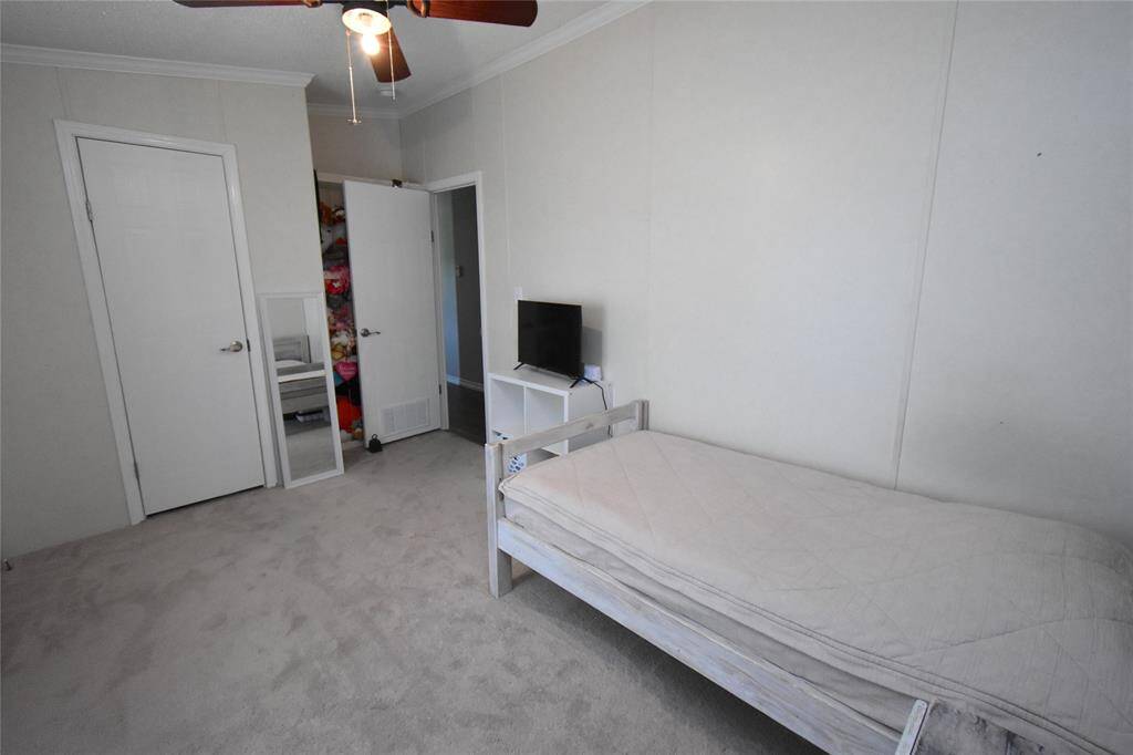 This bedroom features a single bed, neutral walls, and carpeted flooring.