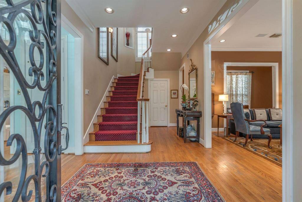 Enter thru iron door. Spacious entry with living room to the right and hall to the left leads to family & dining room. Powder room to the right of white door by stairs.