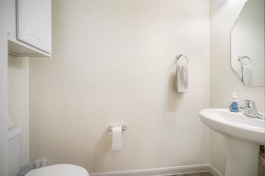 The half bath has a pedestal sink and plenty of storage!