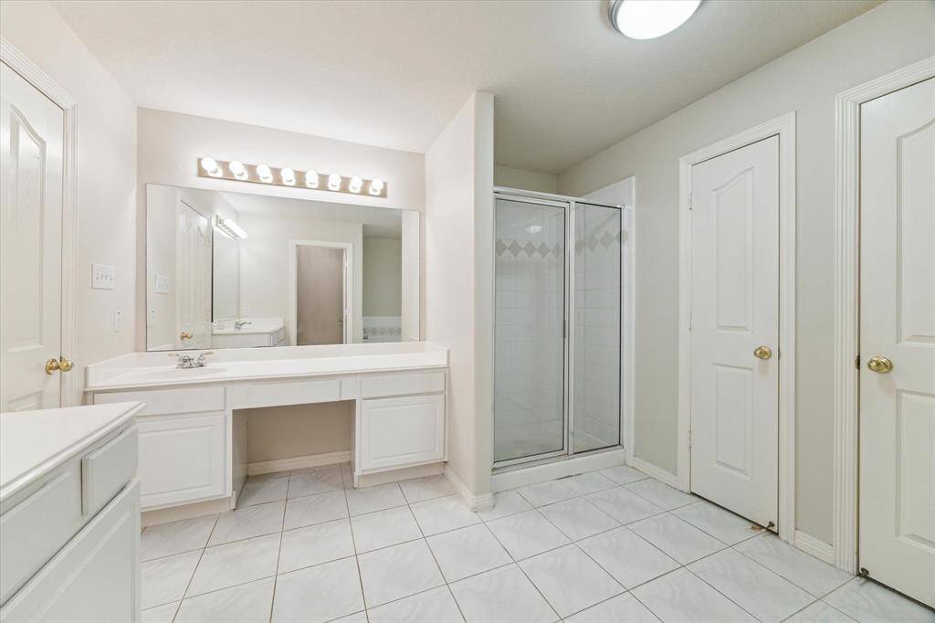The primary bathroom features dual sinks, vanity area, separate shower, soaking tub and linen closet.