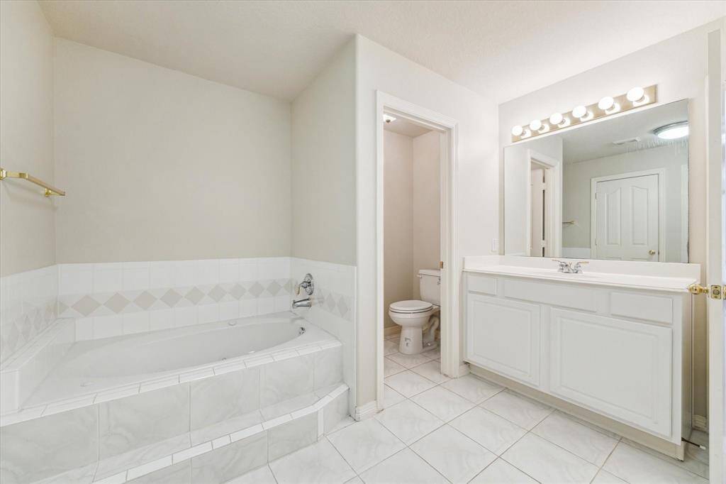 Another view of the primary bathroom, highlighting the separate water closet.
