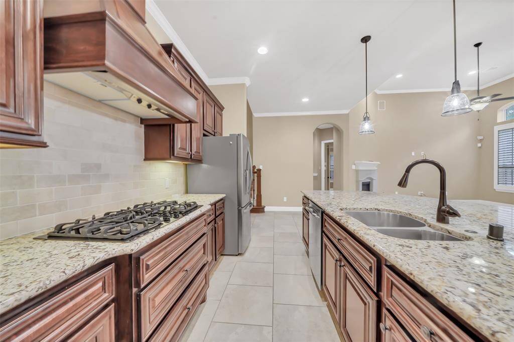 The spacious island serves as both a prep area and a gathering spot, illuminated by modern pendant lighting
