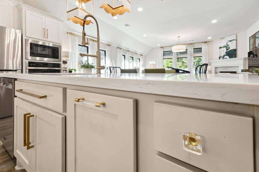 The clear acrylic and honey gold accented cabinet hardware brings a modern appeal to the timeless beauty of the kitchen.