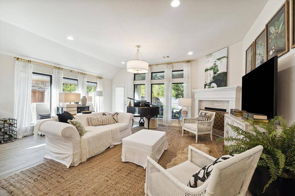 An abundance of natural lights flows into this spacious living area from the six tall windows that line two of the walls.  There’s room for your living room furniture, a large TV, and a piano! Crisp white Italian linen curtains from Restoration Hardware adorn the eight windows in the dining and living areas. Stylish, contemporary square-shaped curtain rods and rings are from Ballard Designs.