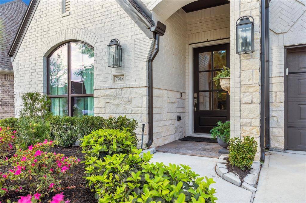Elegant lamps flank the six-paned wooden front door. The owner upgraded to sleek, black windows adding a modern touch.
