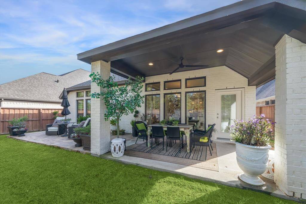 The covered patio has a high ceiling, recessed lighting and a dark-bronze ceiling fan. Enjoy protection from the elements under the cover and add an outdoor kitchen!