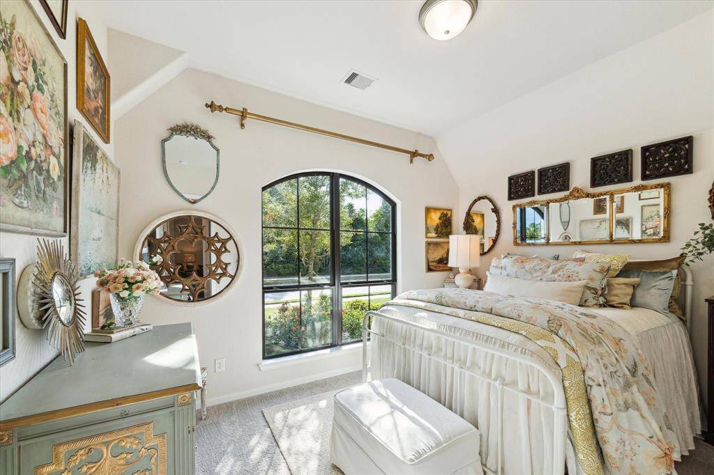 This is the first guest bedroom at the front of the house that overlooks the landscaped front yard and the wooded greenspace across the street.  The wide arched window and angled high ceiling give the bedroom enchanting character.