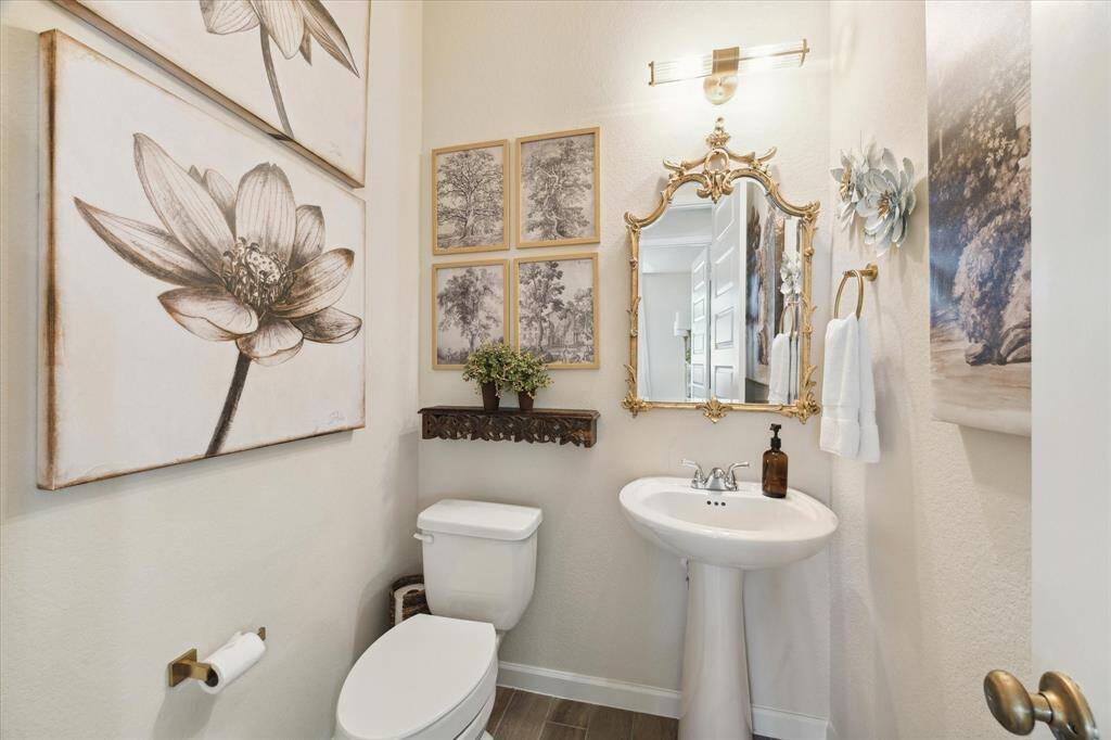 This special half bath for your guests features upgraded lighting and a gorgeous mirror from Horchow. Note the upgraded doorknob as well.