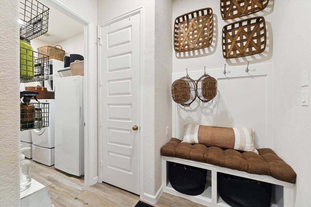 A very functional mudroom is located between the garage and the laundry room.  Built in cubbies, bench and hooks help keep busy people organized!