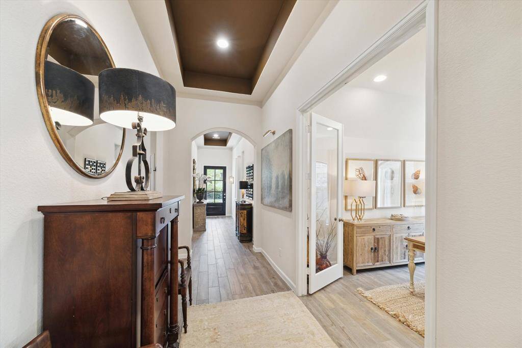 Full view of the entry hall and a peek into the flex space which could serve as a 4th bedroom.  The two tray ceilings help define the area between the guest bedrooms and the flex space.