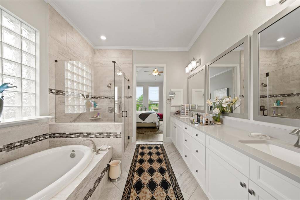 Featuring an extended countertop, two sinks, soaking tub, and a separate shower.