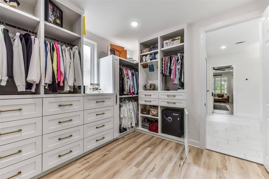 Discover a spacious, well-organized walk-in closet with abundant natural light. Featuring ample hanging space, sleek drawers, and shelving, it’s perfect for keeping your wardrobe tidy and accessible. Experience luxury and practicality in one stylish space.