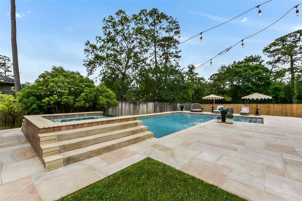 Experience luxury living with this stunning backyard oasis featuring a sparkling pool and elegant stone patio. Perfect for entertaining or relaxing in a serene, landscaped setting.