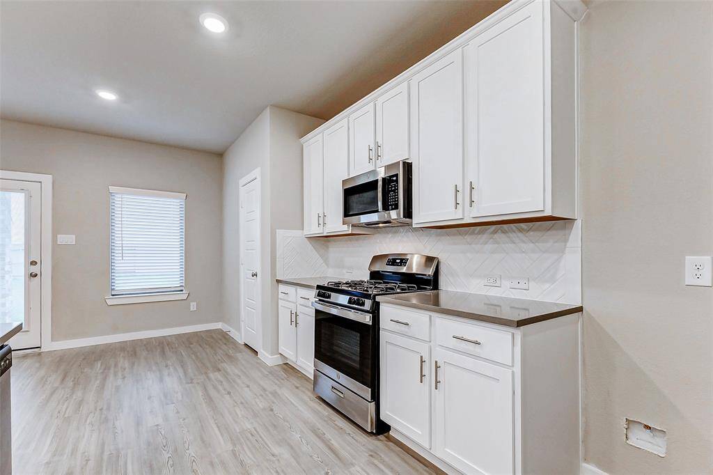 A chef’s dream kitchen with gleaming quartz countertops, a deep stainless steel sink, and high-quality appliances. The herringbone backsplash adds texture and elegance, while ample cabinet space ensures functionality meets style in this well-designed culinary haven.