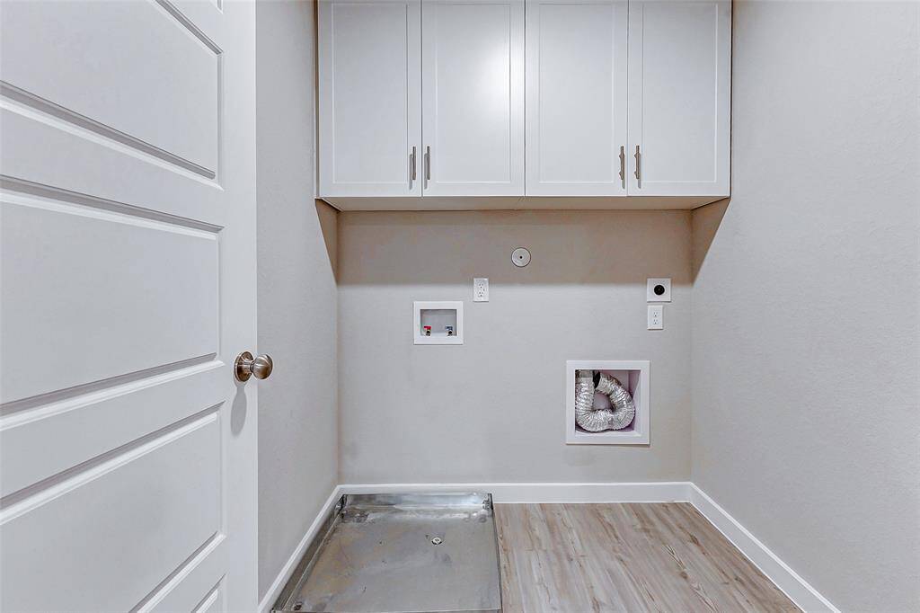Simplify your daily chores in this efficient laundry room with sleek white cabinetry for added storage. The dedicated space ensures convenience and functionality.