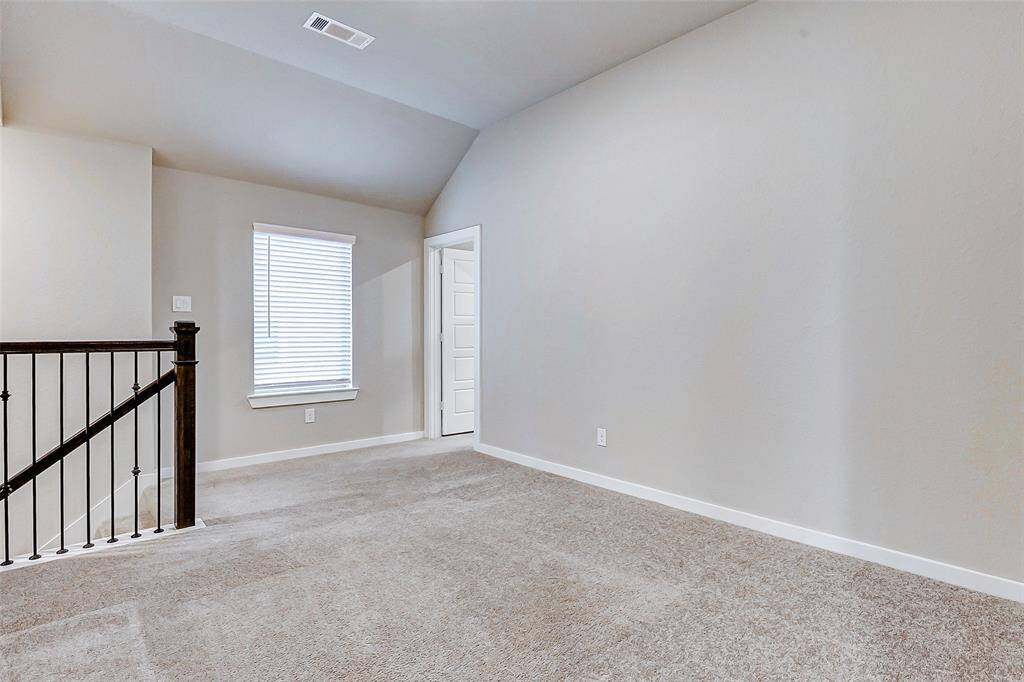 An upstairs flex space with plush carpeting and abundant light awaits your creativit ideal for a media room, home office, or cozy reading nook.
