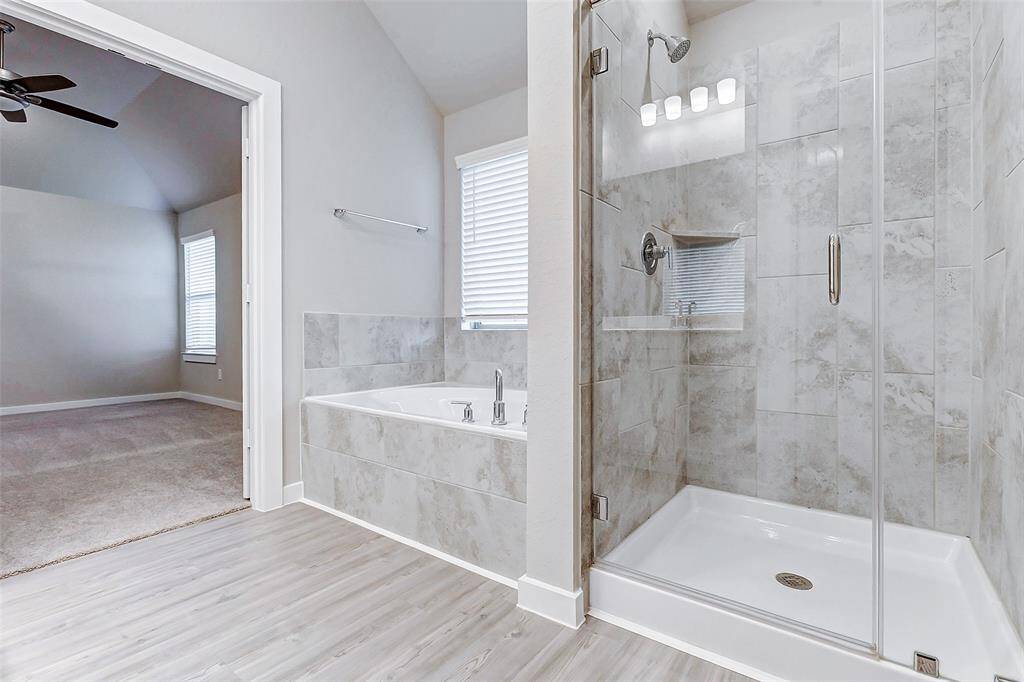 The en suite bath is a sanctuary of comfort, connecting seamlessly to the primary bedroom. Enjoy a luxurious soaking tub, sleek walk-in shower, and soft natural light creating a serene and calming space to unwind after a long day.