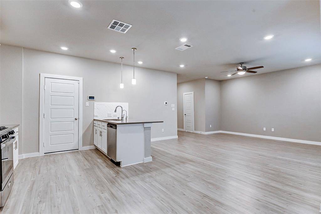This open-concept layout connects the kitchen, dining, and living areas seamlessly, offering a spacious and airy feel. The sleek design features recessed lighting, large windows, and elegant finishes, making it ideal for entertaining guests or relaxing in style.