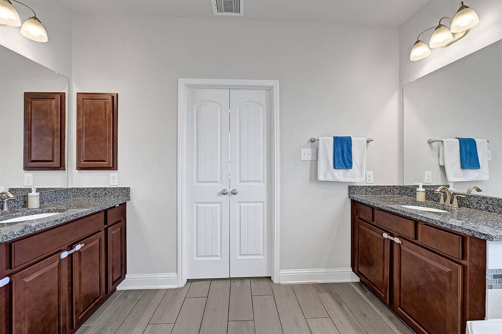 Your separate glass framed shower boasts a grey porcelain shower surround accented with glass mosaic tile and granite shower seat.