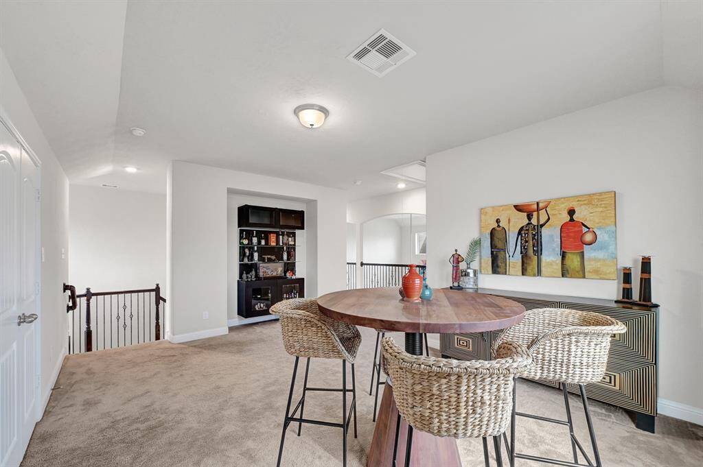 The second floor guest room features tall ceilings, plush carpeting, natural lighting, neutral paint, and modern ceiling fan.