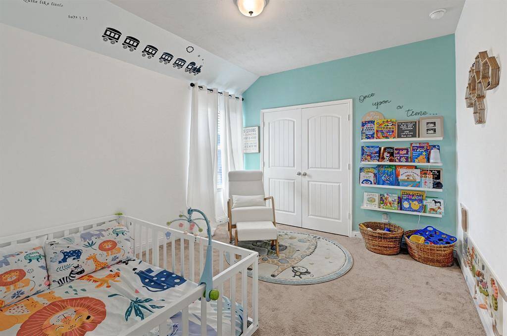 The fourth bedroom is also located on the second floor featuring plush carpeting, modern ceiling fan, neutral paint, private walk-in closet, a large window allowing ample natural lighting, and tall ceilings.