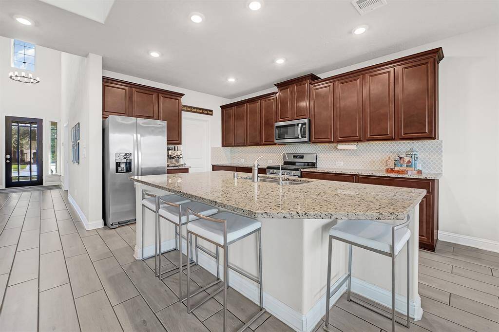 The stunning granite island kitchen is the centerpiece of the home providing ample storage and counter space, sleek stainless steel appliances, and the perfect seating & entertaining area.