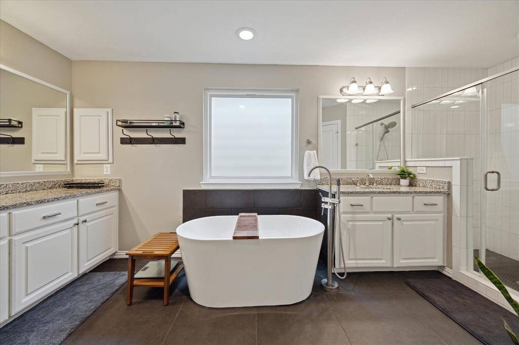 The primary bath was recently and thoughtfully updated with a gorgeous soaking tub, new tile flooring, shower tile, paint and special touches.  Double vanity, huge shower and lots of natural light though the privacy window.  Tons of space to share during morning routines